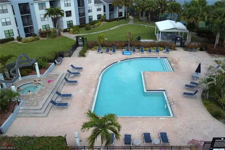 Community pool with a patio and a hot tub