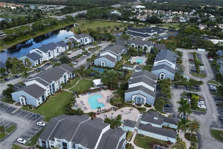 Aerial view of property and surrounding area with a pool and a nearby body of water