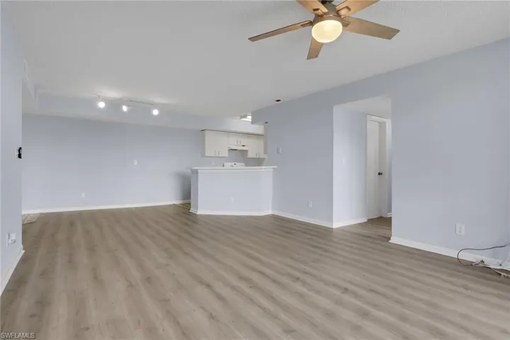 Unfurnished living room with light wood-style floors and a ceiling fan