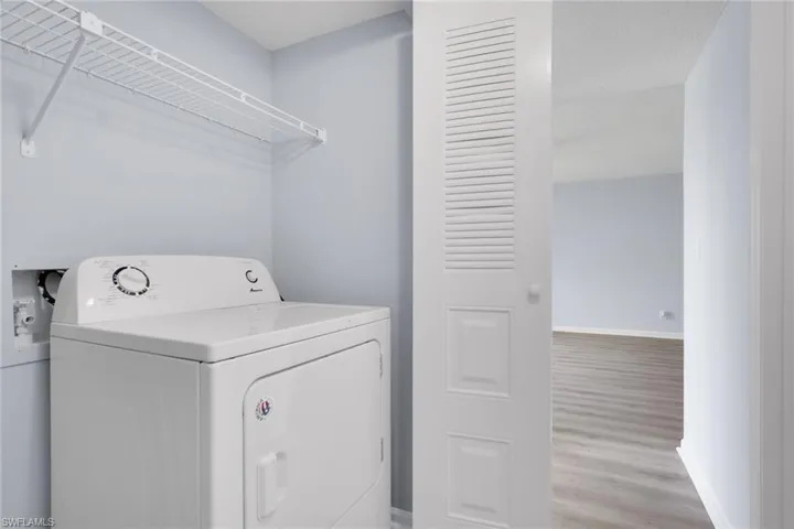 Laundry room featuring washer / clothes dryer and wood finished floors