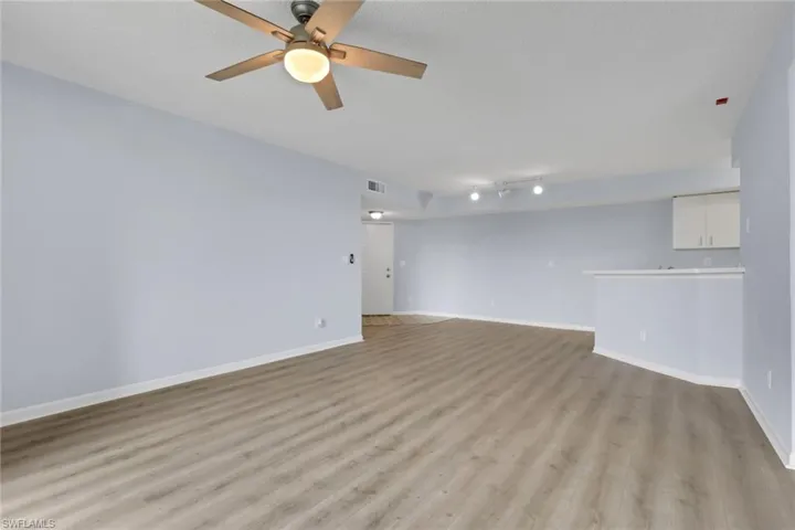 Unfurnished living room featuring light wood-type flooring and ceiling fan