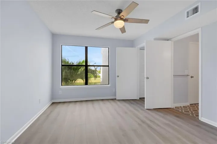 Unfurnished bedroom with light wood-type flooring, ceiling fan, and a textured ceiling