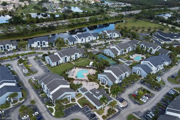 Aerial view of property's location featuring a nearby body of water and a pool