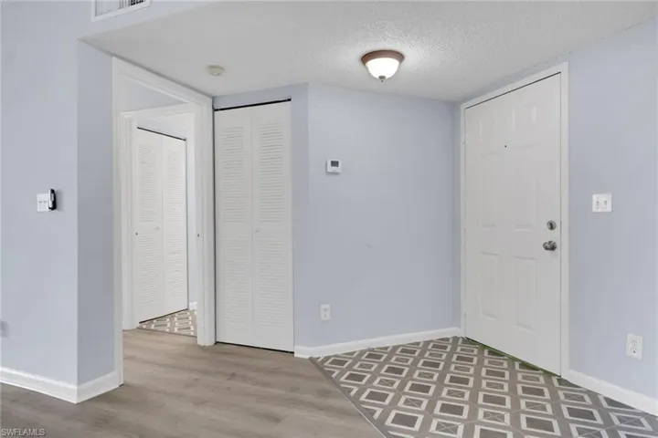 Foyer with a textured ceiling and light wood-type flooring
