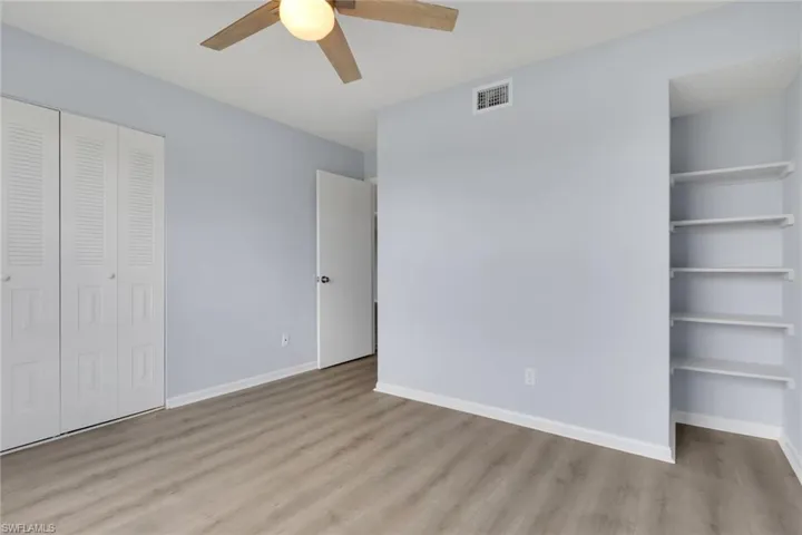 Unfurnished bedroom with a closet, light wood-style flooring, and a ceiling fan