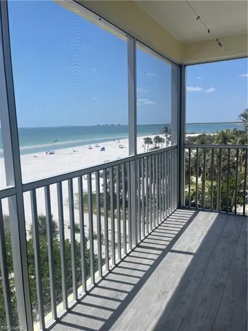 Balcony featuring view of water and beach