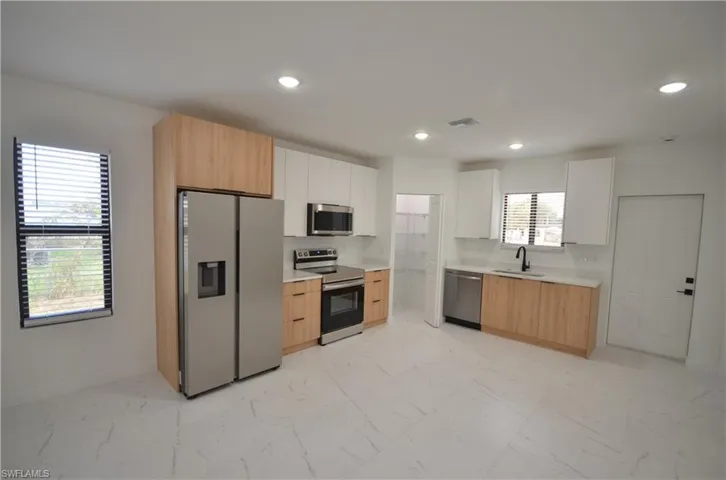 Kitchen featuring visible vents, recessed lighting, a sink, stainless steel appliances, and marble finish floor