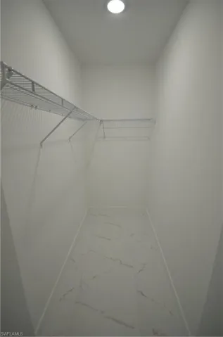 Walk in closet with marble finish floor