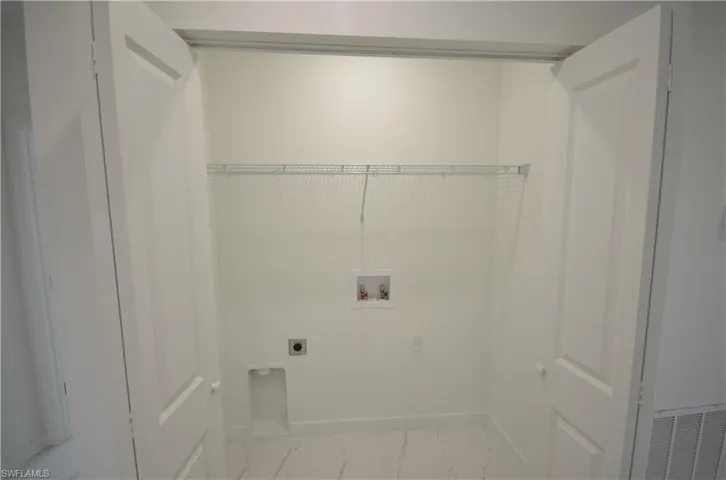 Laundry area with hookup for a washing machine, baseboards, hookup for an electric dryer, laundry area, and marble finish floor
