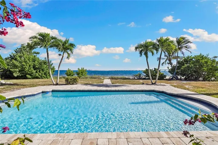 Outdoor pool featuring a water view and a patio