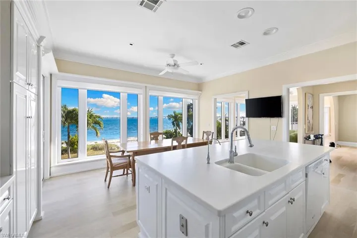 Kitchen featuring white cabinets, plenty of natural light, light wood-style floors, crown molding, and recessed lighting