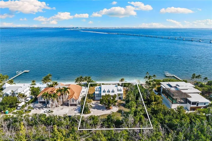 Aerial view of residential area with property parcel outlined and a large body of water