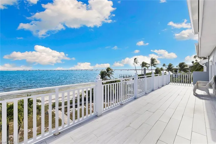 Wooden terrace featuring a water view and a patio area