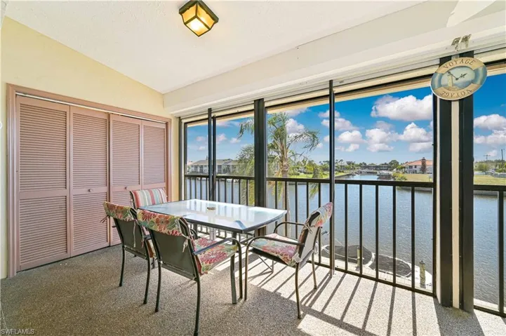 Sunroom featuring lofted ceiling and a water view