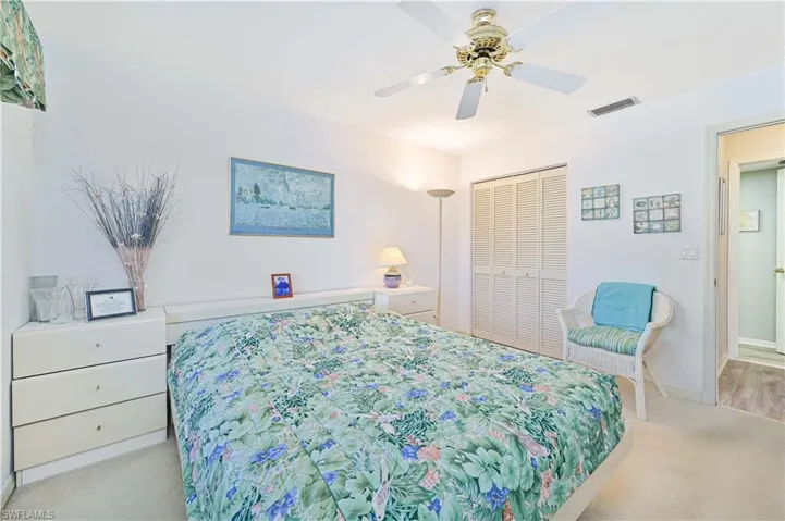 Bedroom featuring light colored carpet, a ceiling fan, and a closet
