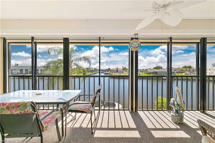 Sunroom featuring a residential view, carpet, and a water view