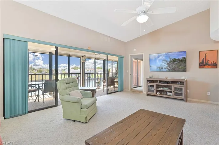 Living area with carpet, lofted ceiling, and ceiling fan