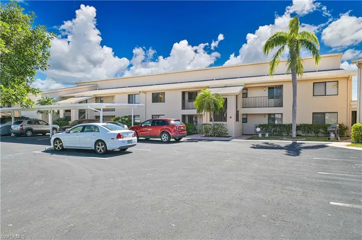 View of building exterior featuring uncovered parking