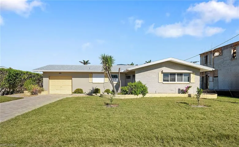 Single story home featuring a garage and a front yard