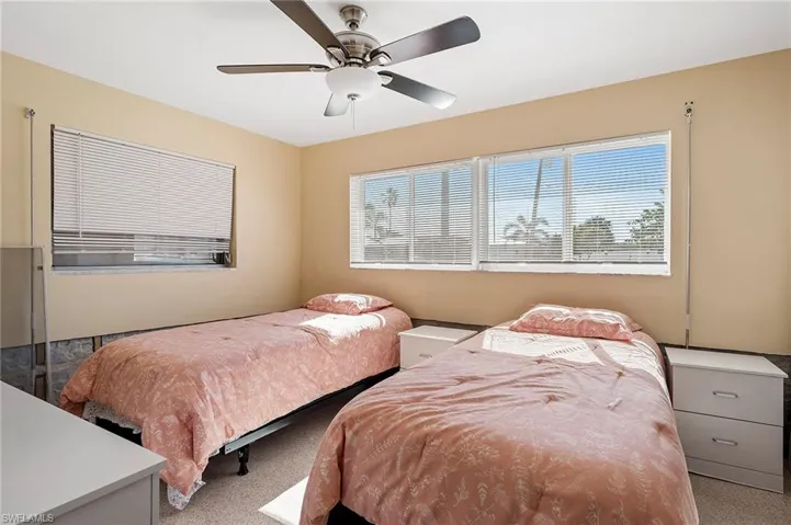 Terrazzo floor bedroom featuring ceiling fan and drywall cut