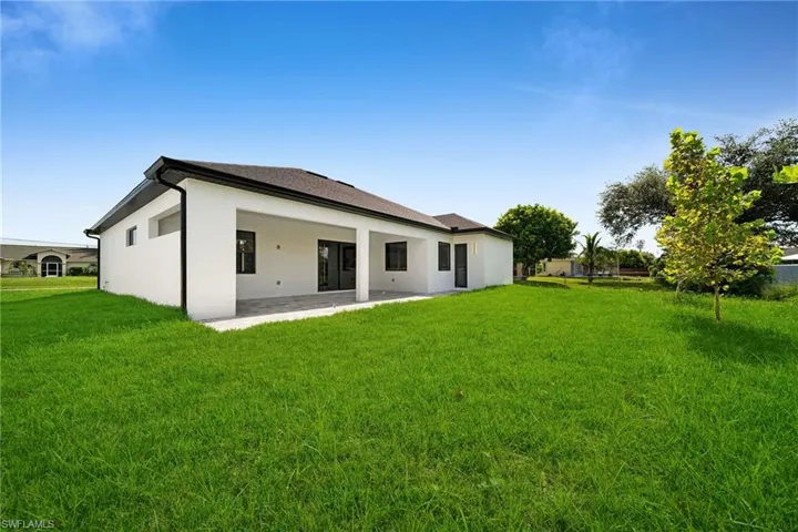 Back of house featuring a yard and a patio area