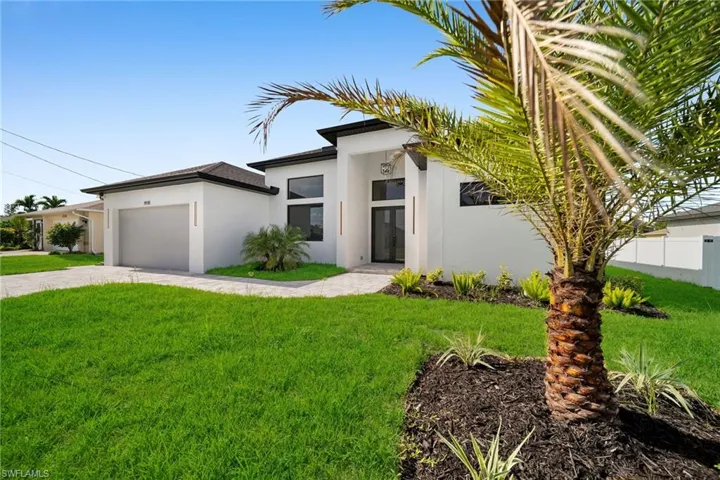View of front of property featuring a garage and a front yard