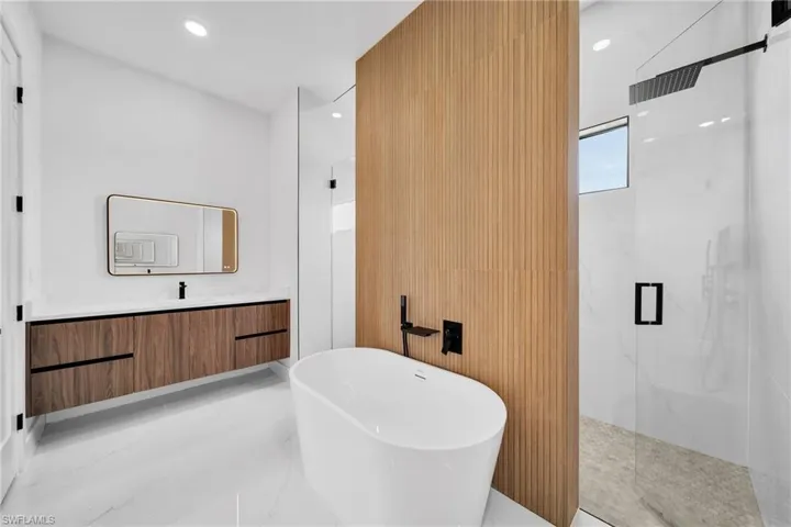 Bathroom featuring shower with separate bathtub, tile patterned floors, and vanity