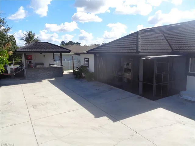Rear view of house with metal roof, concrete patio, and a gazebo