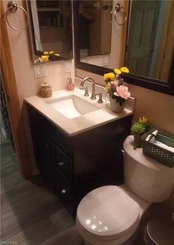 Bathroom 2 featuring vanity and dark wood-style flooring