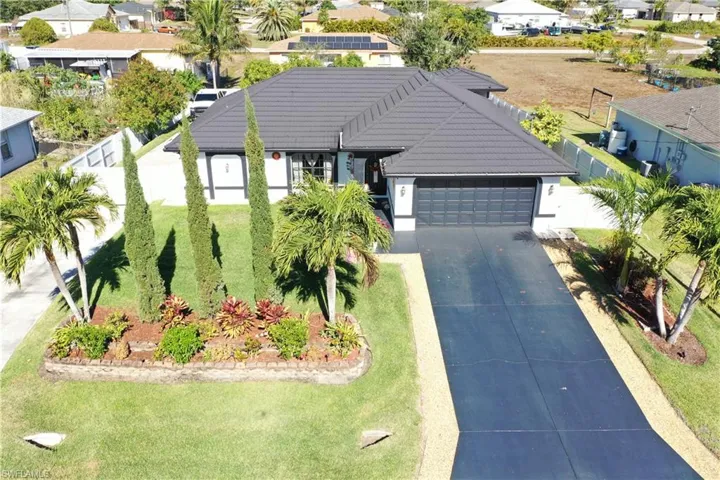 Single story home featuring a residential view, an attached garage, a tile roof, driveway, and stucco siding