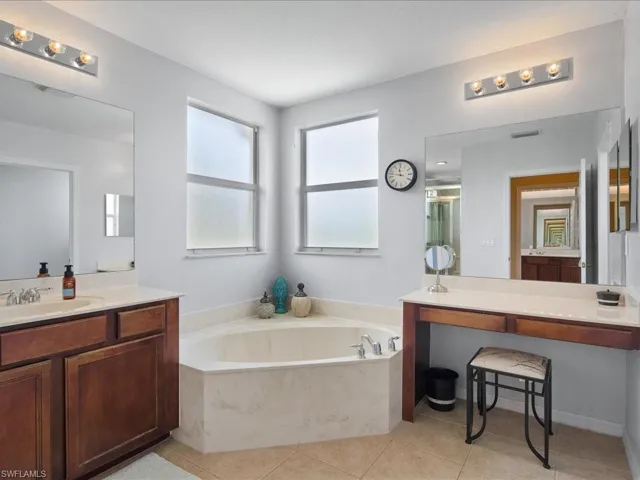 Bathroom with tile flooring, vanity, and a tub