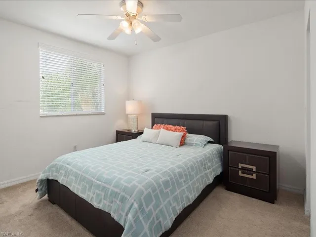 Carpeted bedroom featuring ceiling fan