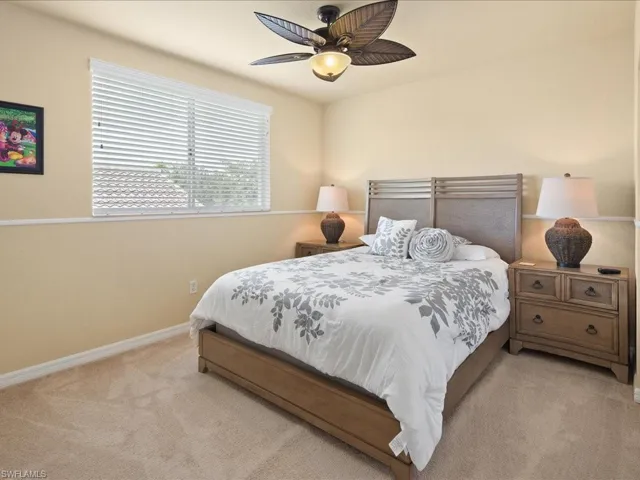 Carpeted bedroom featuring ceiling fan