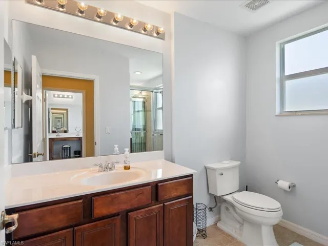 Bathroom featuring toilet, tile floors, and large vanity