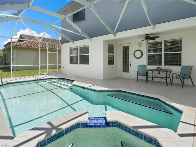 View of pool with ceiling fan, a lanai, and a patio area