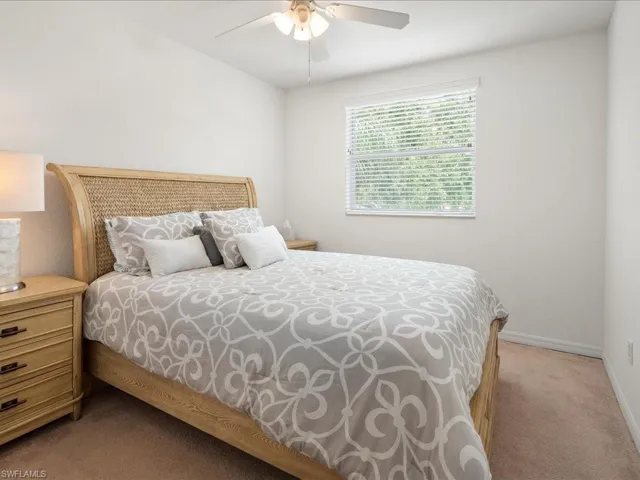 Carpeted bedroom featuring ceiling fan