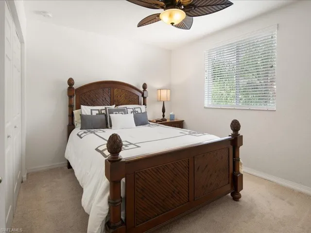 Carpeted bedroom featuring a closet and ceiling fan