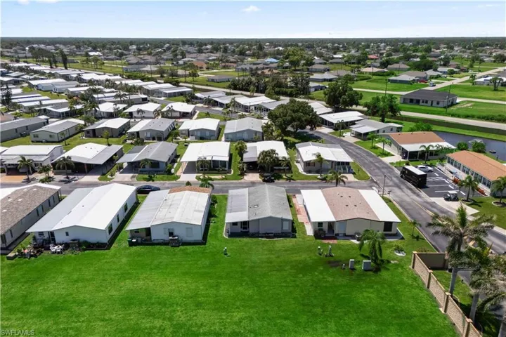 The aerial perspective reveals a spacious, gated community with neatly arranged homes, green spaces, and recreational facilities all within easy walking distance.