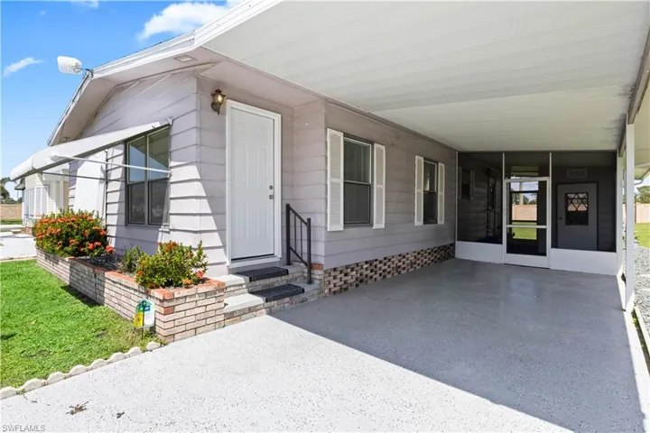 Covered carport with epoxy-finished driveway provides shaded parking and a clean, polished look.