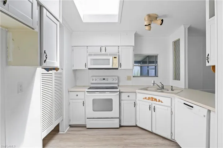 Bright and functional kitchen with ample cabinetry, a breakfast bar, skylight, designed for both convenience and style.