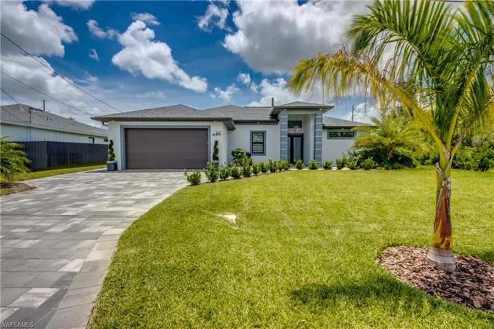 View of front facade featuring a front lawn and a garage