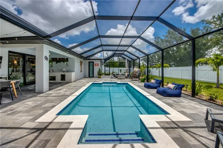 View of pool with a patio and glass enclosure