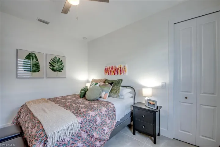 Tiled bedroom with a closet and ceiling fan