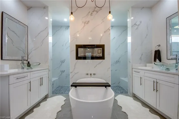 Bathroom with double sink vanity, tile walls, and tile floors