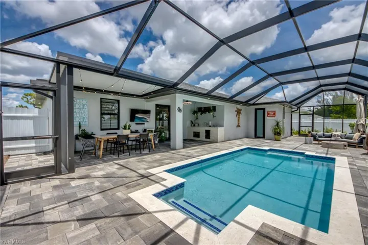 View of swimming pool with glass enclosure, an outdoor living space, and a patio