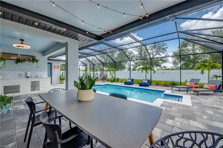 View of swimming pool with a patio area and glass enclosure