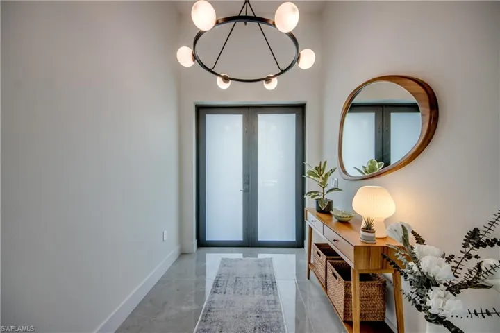 Foyer entrance with a healthy amount of sunlight, french doors, and concrete flooring