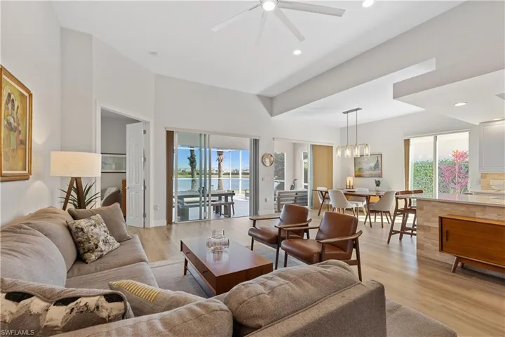 Living room with a wealth of natural light, light vinyl plank flooring, and a water view.