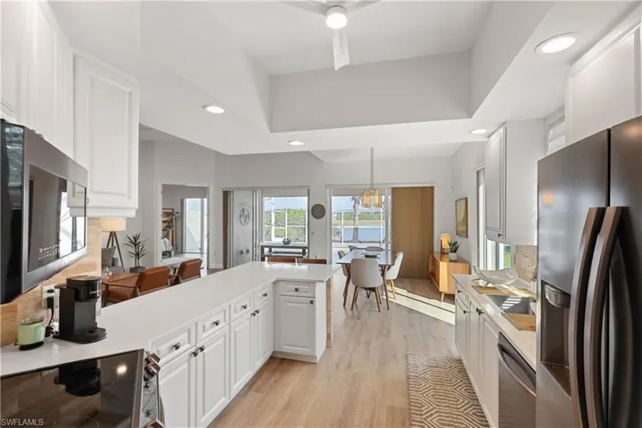 Kitchen featuring kitchen peninsula, pendant lighting, white cabinets, and stainless steel appliances