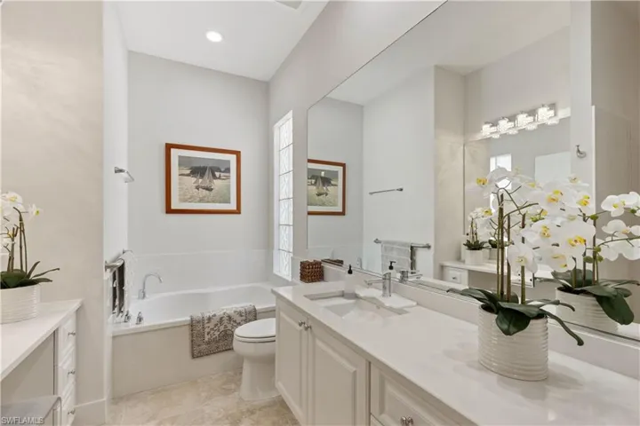 Bathroom with a washtub, vanity, and toilet